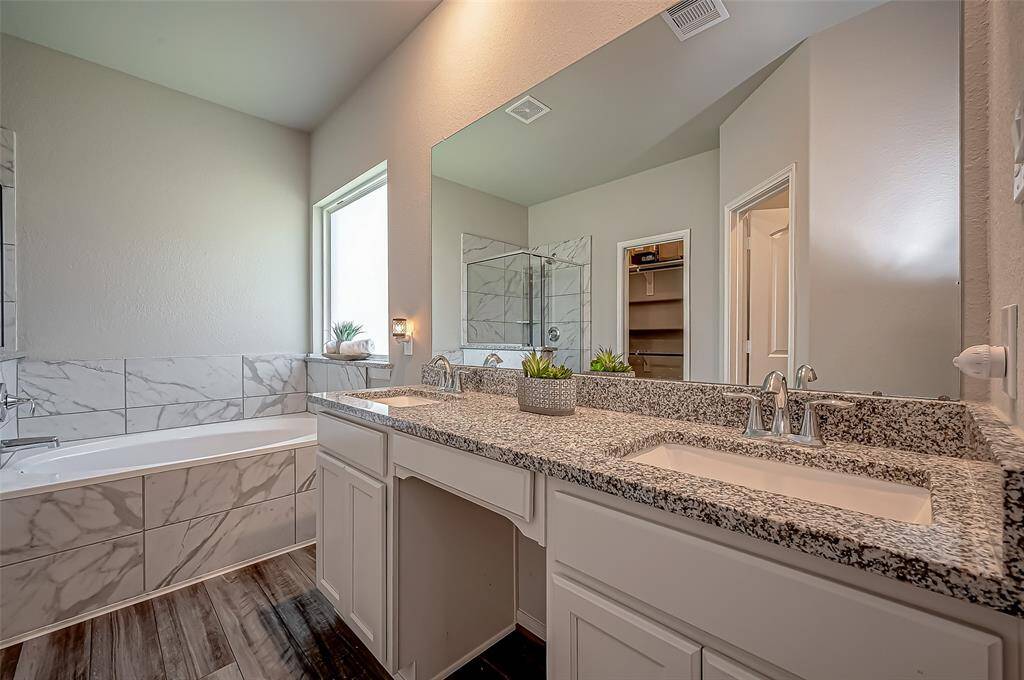 Step into your primary bedroom and be greeted by the double sinks, providing ample space for you and your partner to get ready simultaneously. The bathroom is equipped with a spacious shower for a refreshing start to your day and a soaking tub perfect for relaxing after a long day.