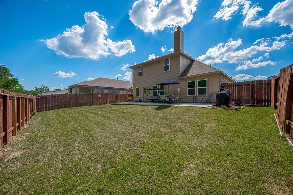 The large backyard is fully fenced, ensuring privacy and security, making it an ideal space for children and pets to play safely.