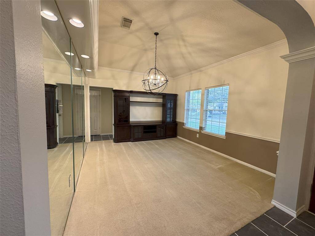 Just off the entryway, this spacious dining room features a striking modern chandelier, windows that invite natural light, and an elegant mirrored accent wall, creating a bright and open feel. It's the perfect space for hosting gatherings or enjoying everyday meals in style.