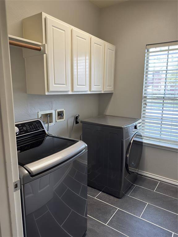 This refreshed utility room features fresh paint and newly installed tile flooring for a clean, modern look. Upper cabinets provide ample storage, while both gas and electric connections for the dryer offer flexibility. A dedicated electric hookup for the washer ensures convenience in this well-equipped space