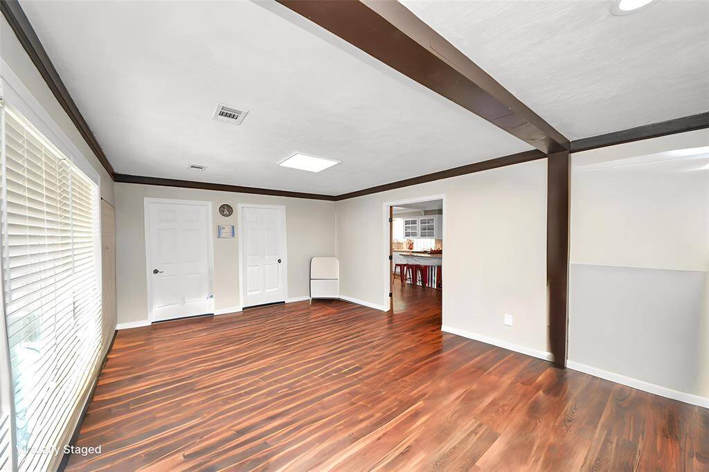 The living area is now being used as a reception area.  The two doors lead to the two small offices which could easily be converted back.