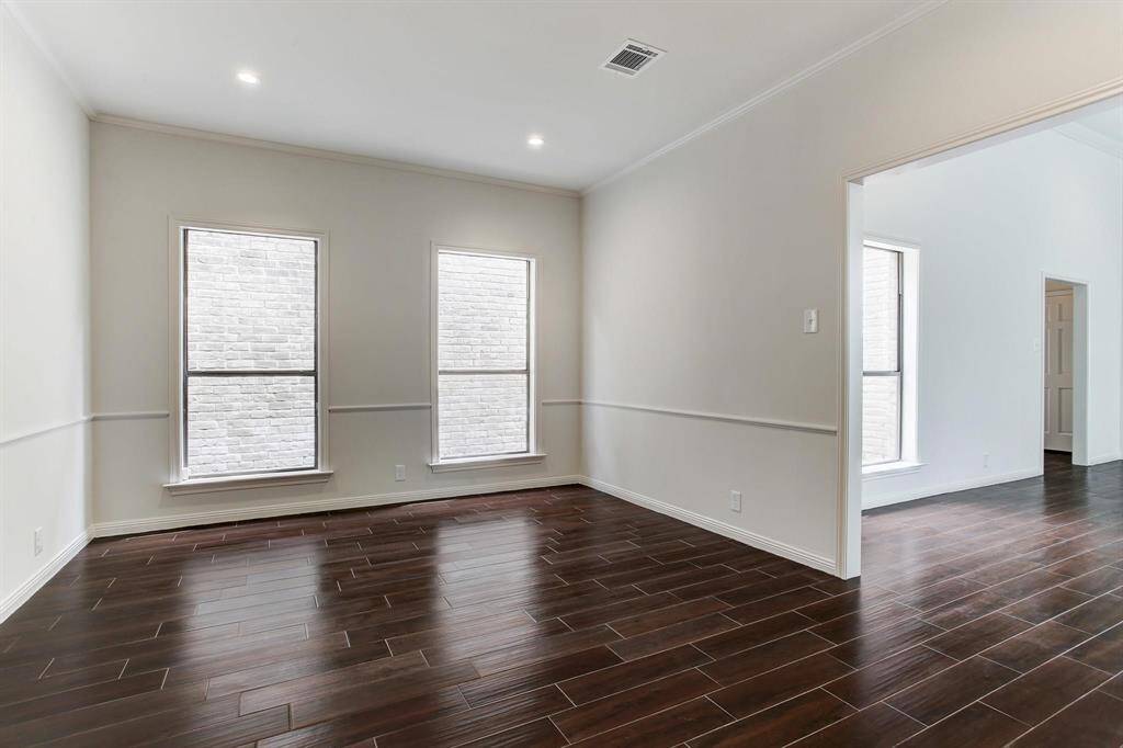 Formal dining room has two large windows overlooking private walkway, recessed LED lighting and chair molding.