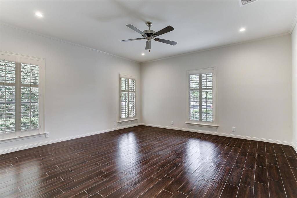 Spacious primary suite features large windows with plantation shutters, ceiling fan and recessed LED lighting.