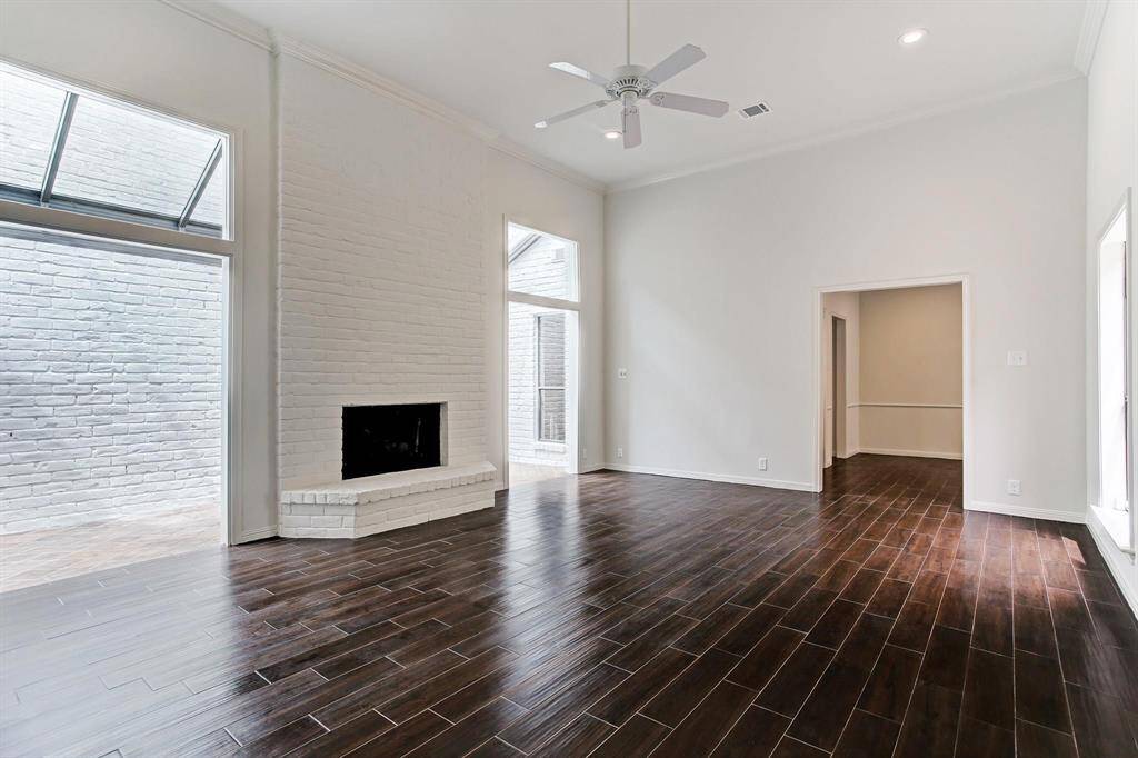 Spacious living room with soaring 12' ceiling, new recessed LED lighting, wood-look porcelain tile flooring and access to charming sun room.