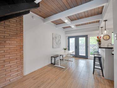Great beamed ceiling and brick accent wall.