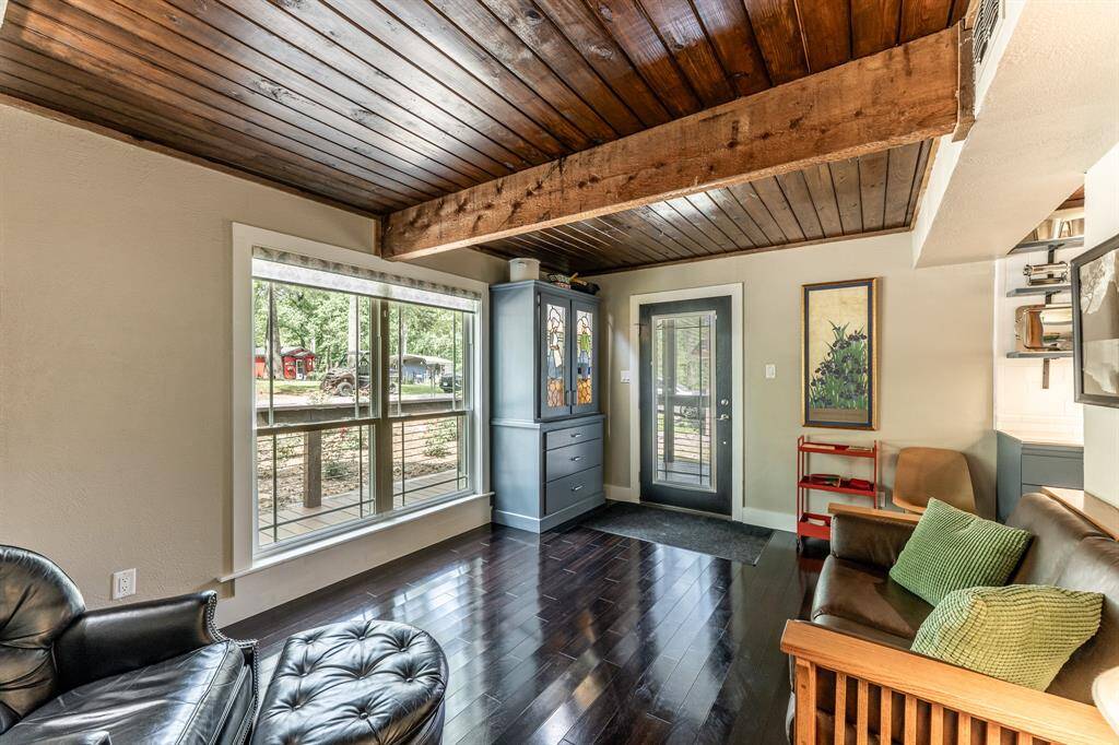 Standing in the doorway to the primary bedroom and looking toward the full view Prairie Lite door with enclosed blinds.  The back porch has a similar (though slightly smaller) dormer to the front door.  The doorway on the right goes into the kitchen.
