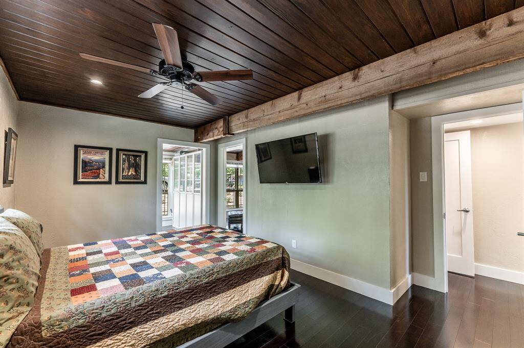 The primary bedroom.  The TV will remain.  Going from left to right, the doors are the laundry room, the entrance into the den, and the entrance into the hall.  The other door you see is the entrance into the bathroom at the end of the hall.