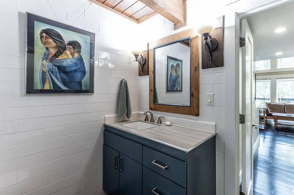 Vanity in downstairs bathroom has plenty of storage and a Moen faucet. Door opens into hall.  Bedroom is to the right of the picture and living room is at the end of the hall.
