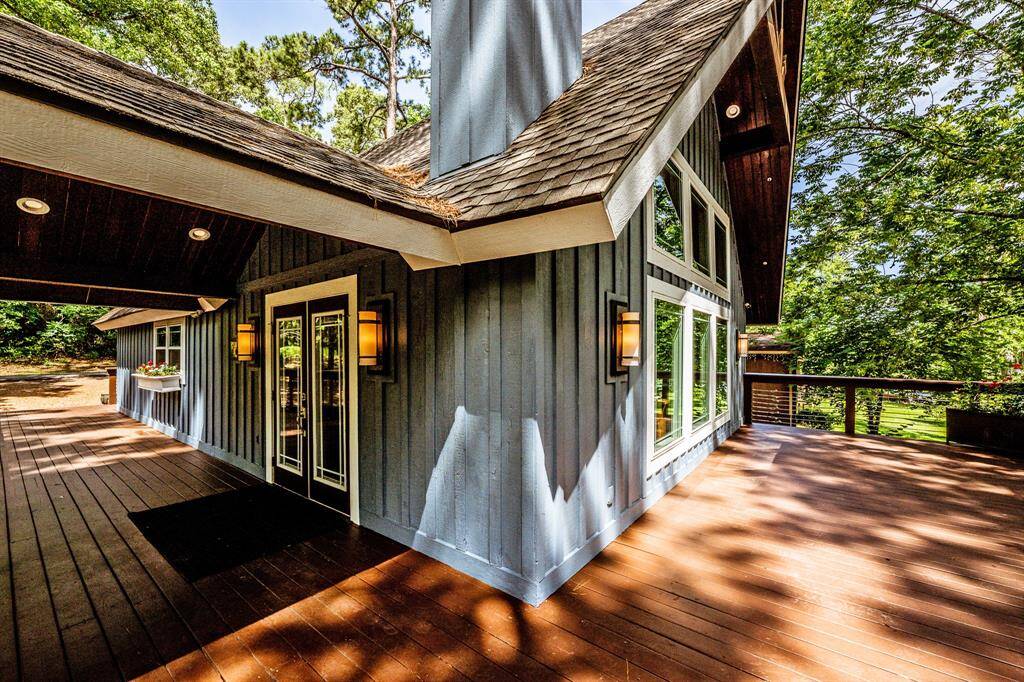 Dormers protect both the front door and the back door. The front door is on the side of the house, and you will notice the Hubbardton Forge wall sconces. The wraparound porch will take you to the back deck overlooking the trees and lake. There are also 4 security cameras that connect to the WIFI that are located around the exterior of the house.
