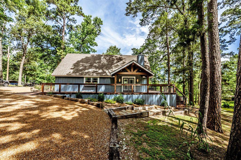 A slightly more complete view of the circular driveway.  Railroad ties make the sides of the driveway and the opening leads to a stair step path hardscaped with pavetones and pea gravel.  The pathway takes you to the steps leading up onto the deck.