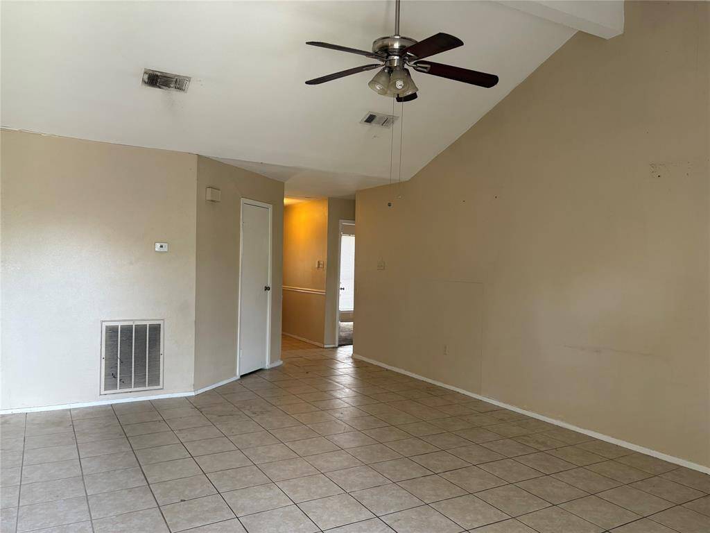 Living room with high ceiling and tile floors