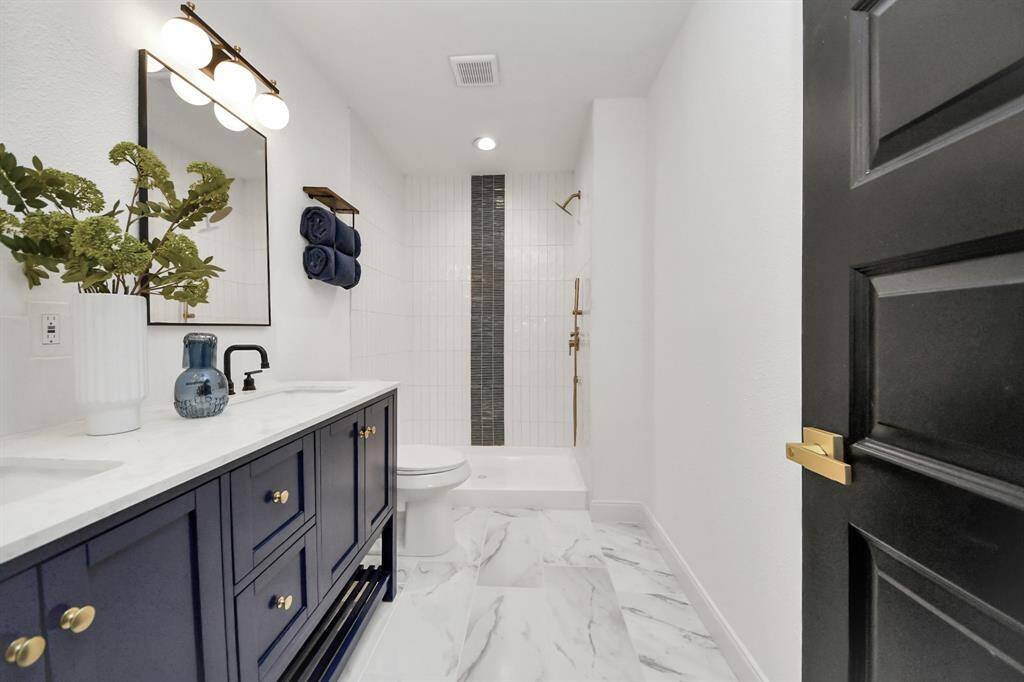 The primary bathroom features tile floors, dual sinks, and a shower with tile surround.