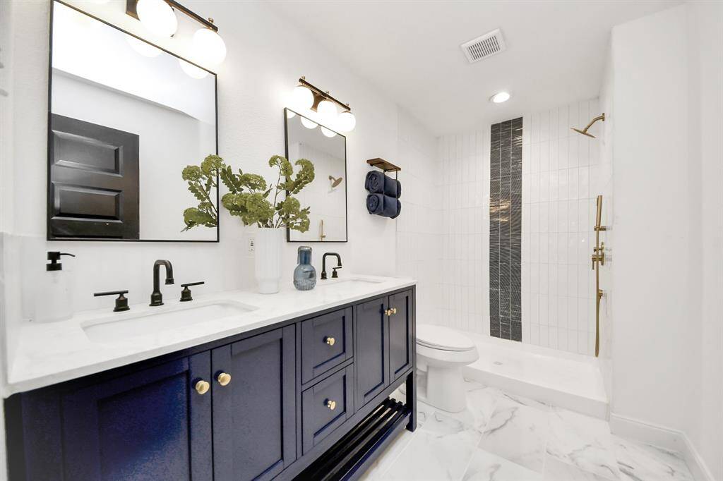 The primary bathroom features tile floors, dual sinks, and a shower with tile surround.
