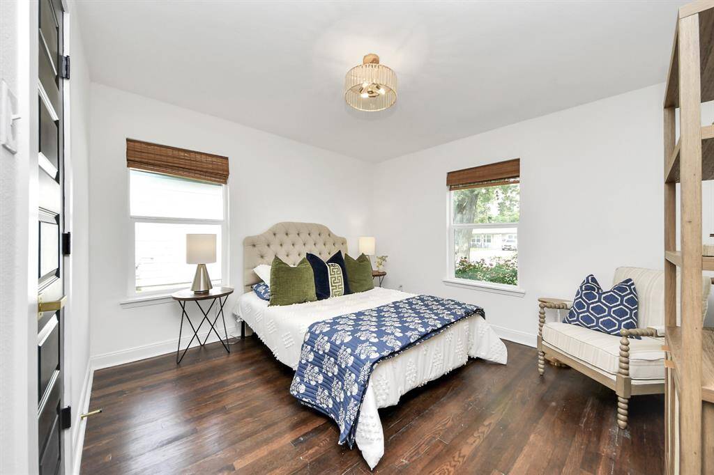 Secondary bedroom features large windows and a modern lighting fixture.