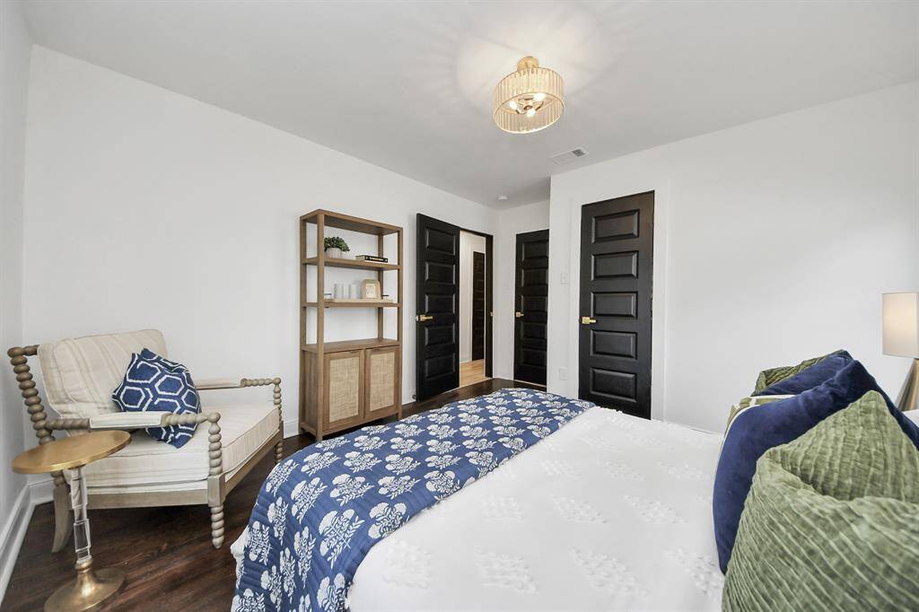 Secondary bedroom features large windows and a modern lighting fixture.