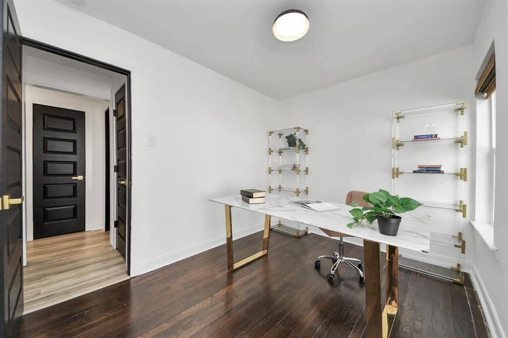 Third bedroom, currently used as a home office, features large windows and a modern lighting fixture.
