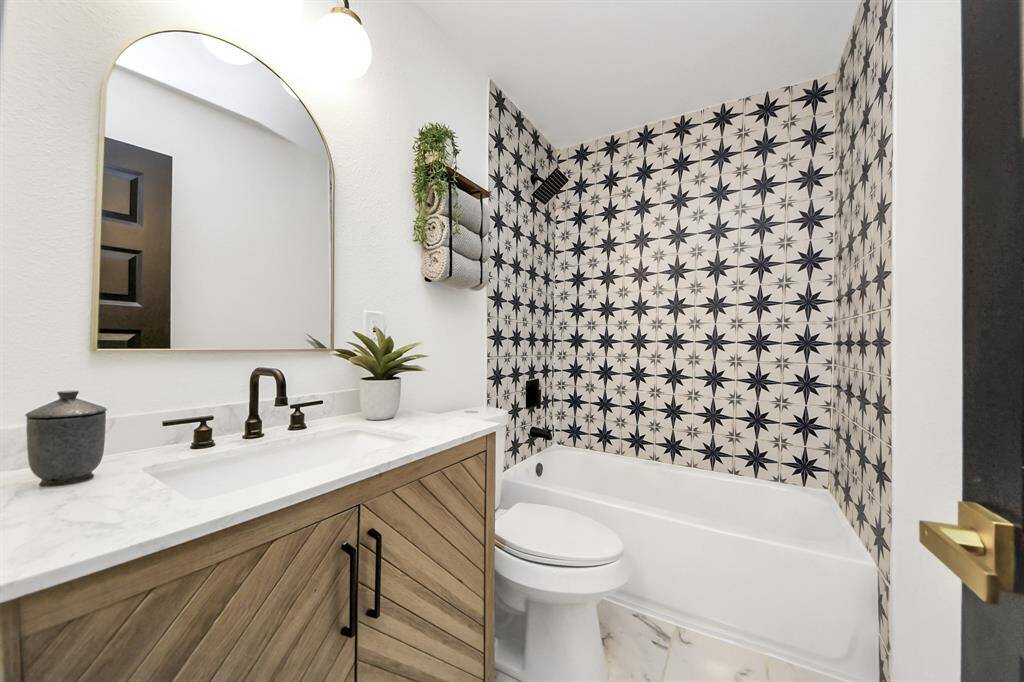 Secondary bathroom features atub/shower combo with tile surround and vanitywith plenty of counter space.