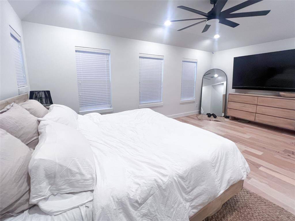 Primary bedroom has so much space and high ceilings. Tons of natural light during the day as this was taken in the evening.King size bed pictured
