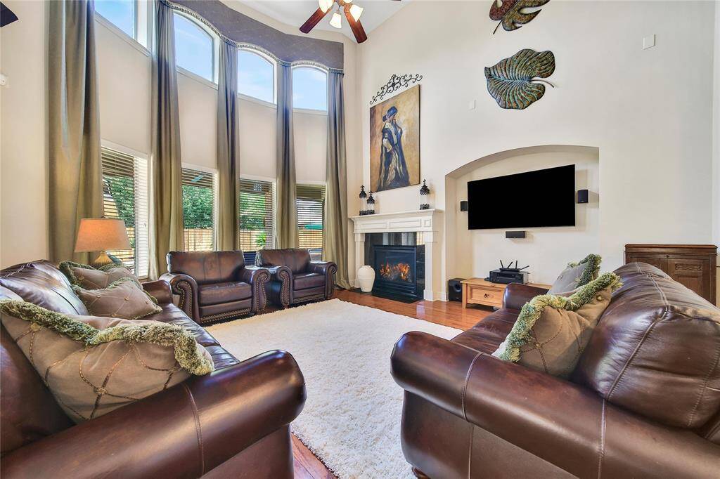 Soaring ceilings accentuate the room’s spaciousness, while a wall of windows offers stunning views of the backyard pool.