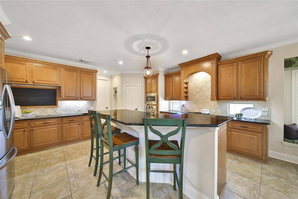 The kitchen boasts a functional layout that seamlessly blends efficiency and flow for everyday cooking and entertaining. A built-in spice rack above the cooktop keeps seasonings within easy reach for convenient cooking.