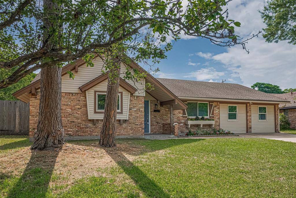 nestled in a lush, tree-lined yard. Features a welcoming front porch and a well-maintained lawn, perfect for family living.