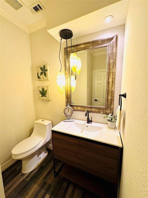 The powder room features a modern vanity with a sleek faucet and a large framed mirror. It includes updated elegant pendant lighting, complemented by a stylish wood-patterned tile floor!