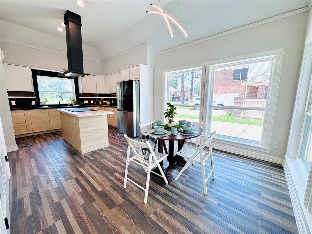 The modern open-concept kitchen and breakfast area with wood tile flooring is durable and beautiful! The large open space will be well utilized when you entertain!