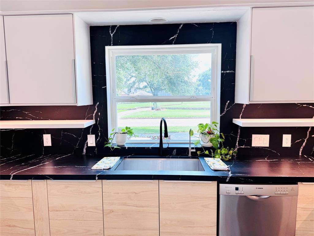 The black and white quartz counters are a beautiful contrast! The wood lower cabinets and white uppers are a blend of natural materials and provide tons of storage!