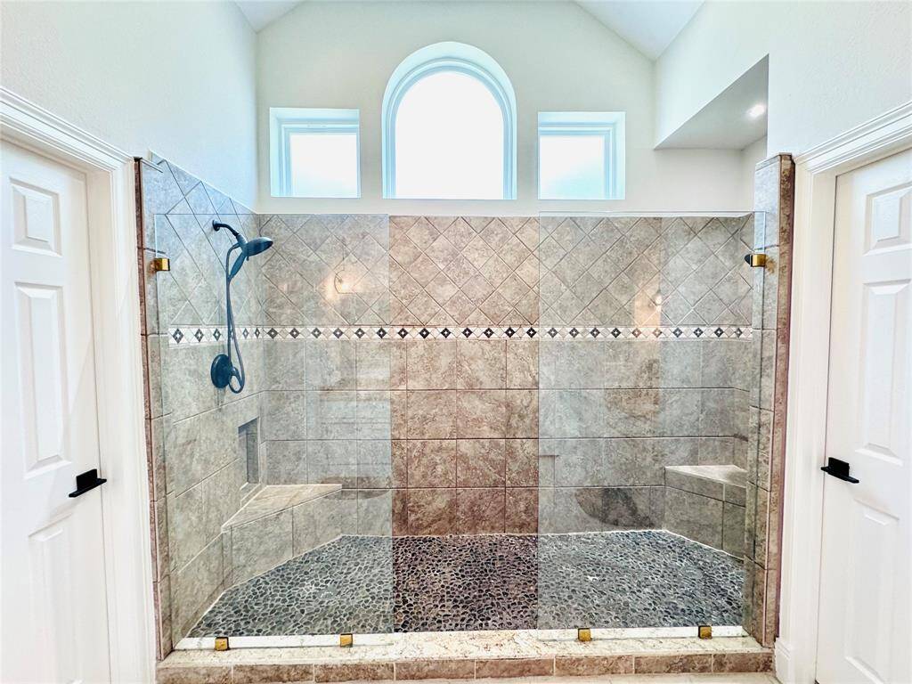 Check this out! So beautiful and functional! A dual shower with custom tile work, smooth pebble flooring and bronze hardware! The private water closet is to the left!