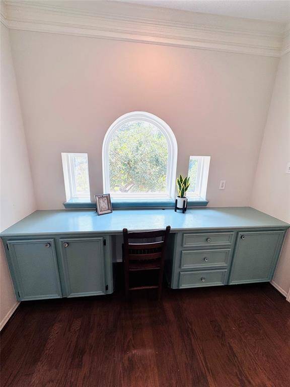 This cozy home office nook give you or a loved one another place to work with a built-in blue desk featuring ample storage and a charming arched window for natural light. It's ideal for productivity and working in style!