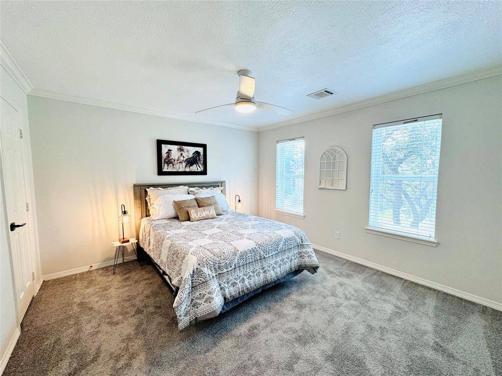 Bedroom Two features an inviting atmosphere with updated plush carpeting and soft-toned walls. Lots of natural light from two large Low E Double Pane Windows. Updated ceiling fan and paint add the finishing touches to this serene space.