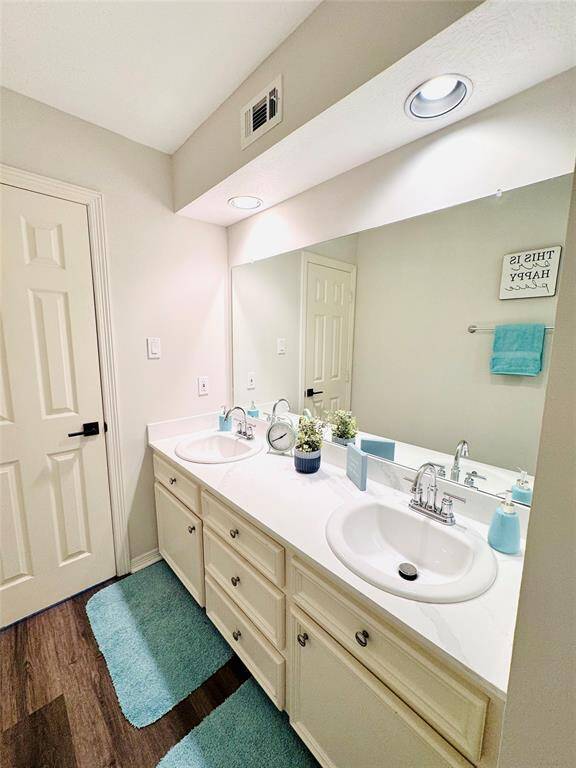This updated bathroom features a double vanity sinks and marble counter with ample storage! Updated paint and LVP wood flooring are featured as well!