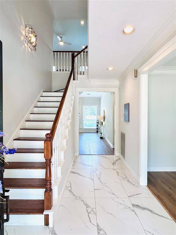 The entry is open to the second floor and has beautiful porcelain marble floors and recessed lighting!