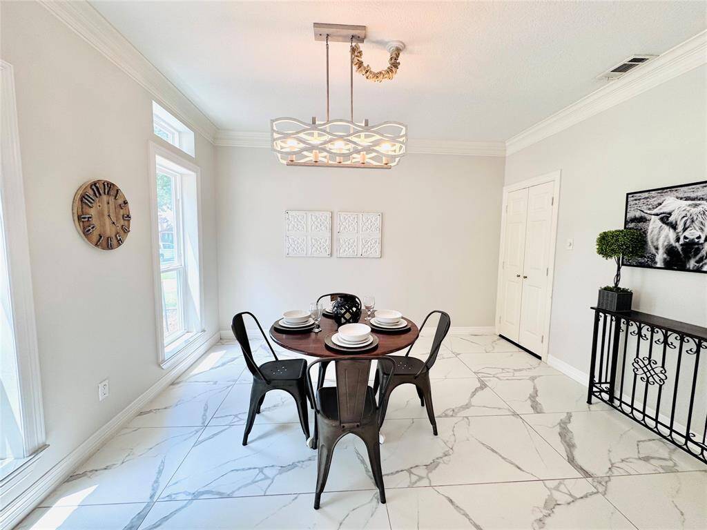 The Formal Dining Room has recent paint, an updated modern light fixture, and elegant marble-style flooring. This space will hold many of your celebrations in style!