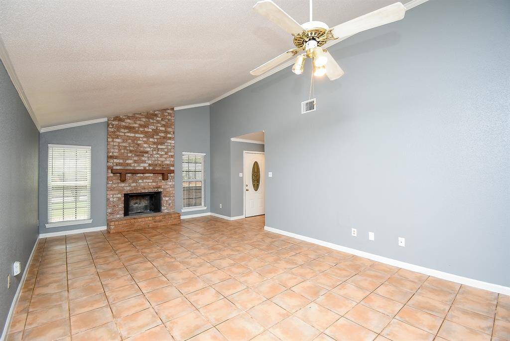 Spacious living and dining area featuring elegant ceramic tile and soaring semi-cathedral ceilings.