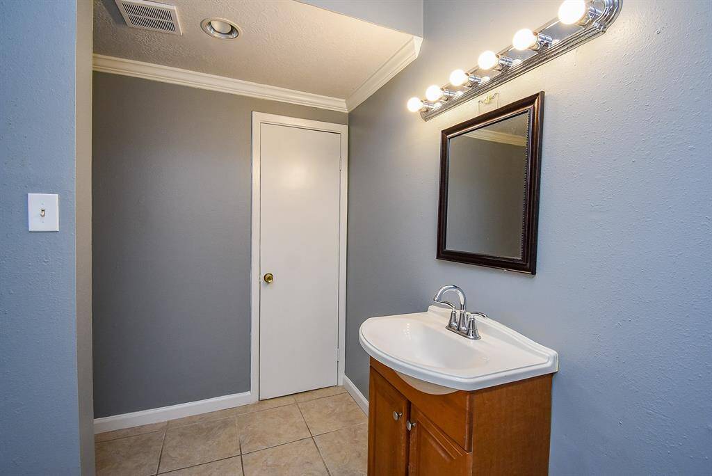 Spacious second master bath with modern finishes and ample lighting.
