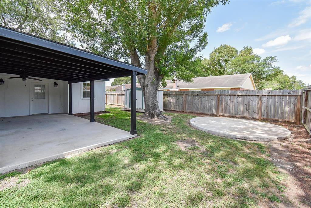 The backyard features a spacious covered patio with concrete flooring and a separate shaded patio, perfect for outdoor dining and relaxation.