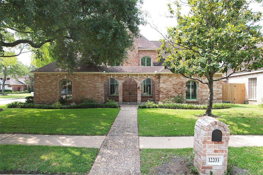 This charming brick home features a classic design with double paned arched windows and plantation shutters and a welcoming gated entry. It's surrounded by a well-maintained lawn and mature trees, offering a serene and inviting curb appeal.