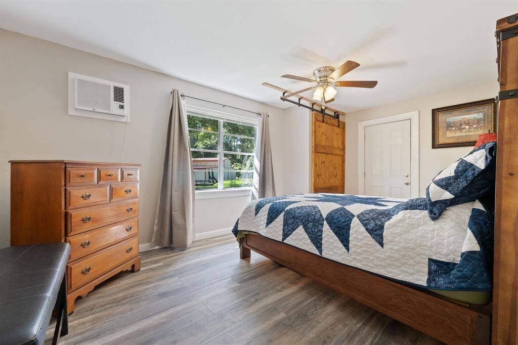 This is the primary bedroom, look at that sliding barn door that has is made for storage!  The utility room is just through the other door.  Gorgeous natural light, and a window unit that cools and heats.