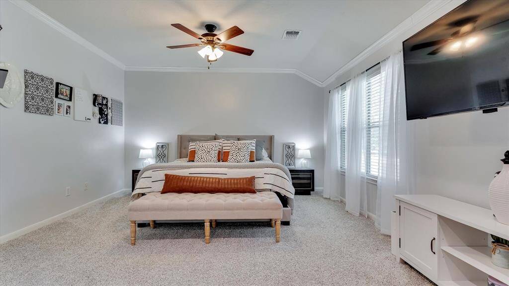Enormous Master Bedroom with crown molding and LED recessed lighting and ceiling fan.