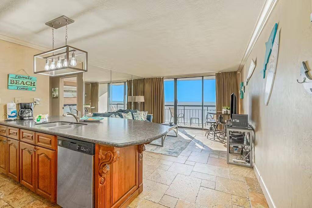 Bright and open layout highlights the living room, kitchen, and stunning Gulf view beyond the sliding glass doors.