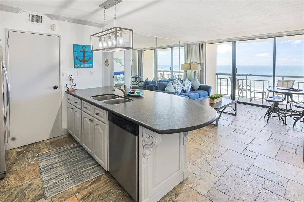 Bright and open layout highlights the living room, kitchen, and stunning Gulf view beyond the sliding glass doors.