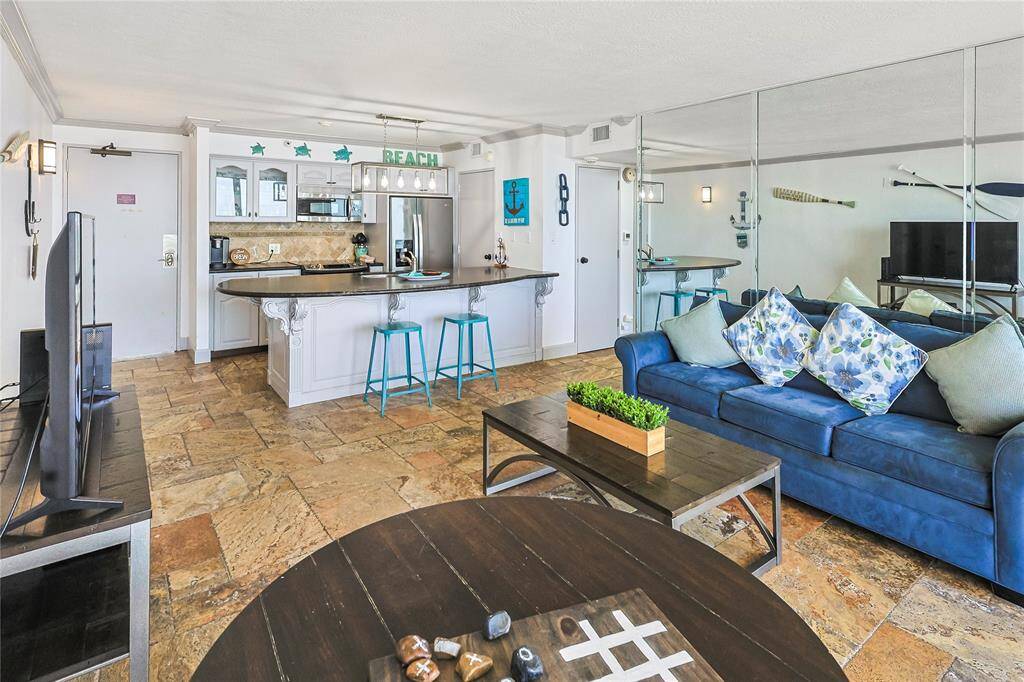 Open-concept living and kitchen area offers generous space and design touches of coastal charm.
