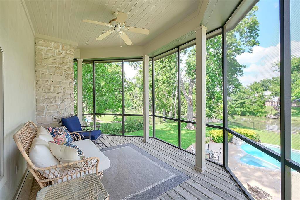 Screened porch off Primary bedroom with view of the pool and Pecan Lake