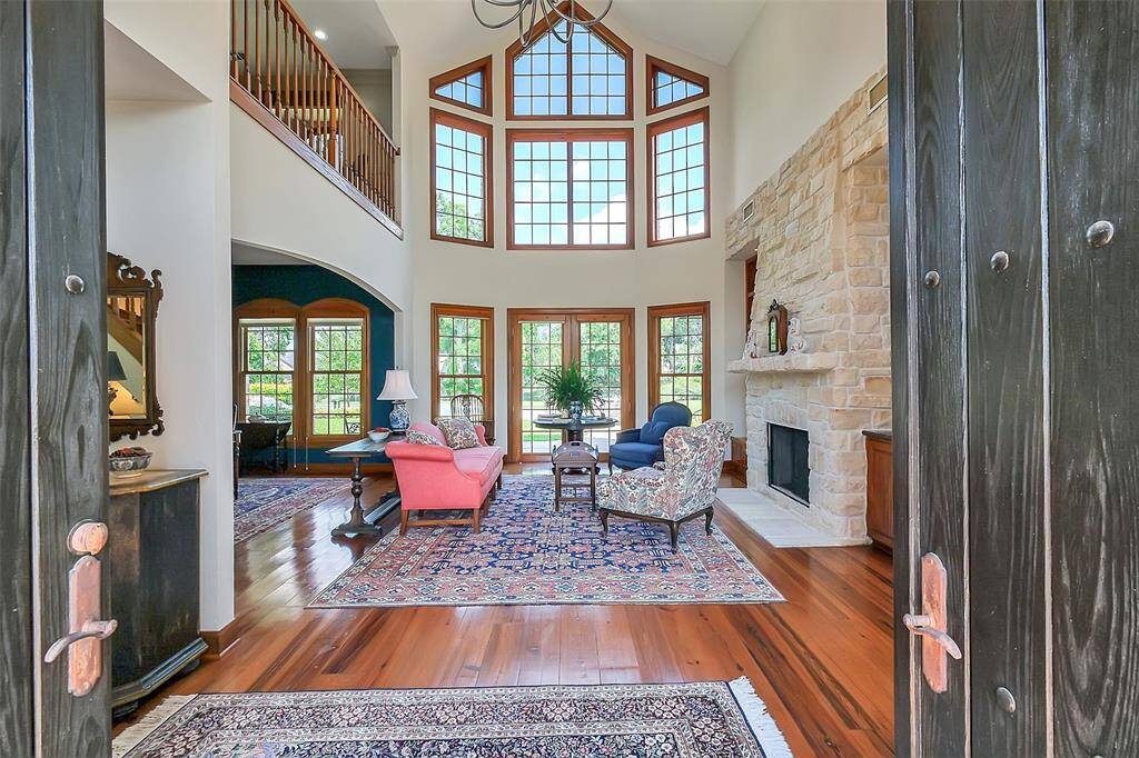 Notice the beautiful wall of windows, solid wood wide plank flooring and stone fireplace