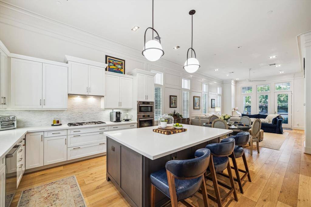 The kitchen features high-end appliances by Miele and Bosch, along with plenty of storage space and an oversized island with quartz countertops.