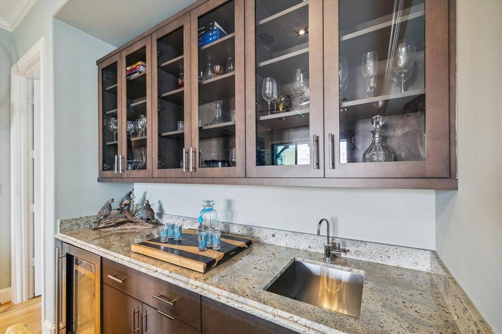 A wet bar with storage and a wine fridge are a highlight in the upstairs game room/den.