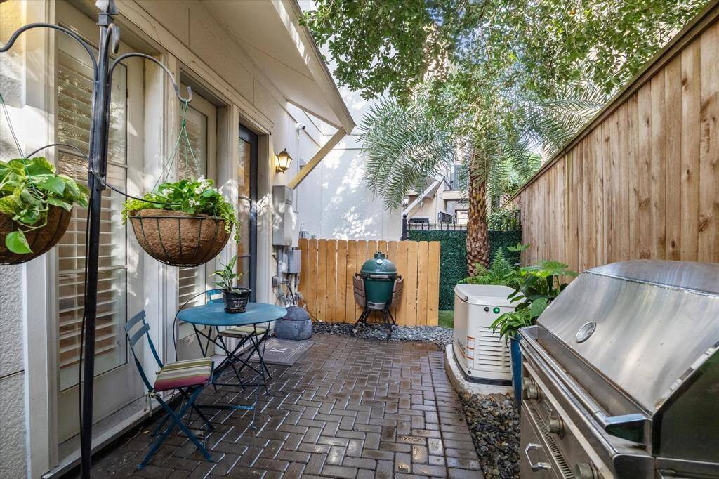 The backyard courtyard space provides a lovely retreat.  There is a brick patio, as well as a spot of turf for any pups and a lovely palm tree for privacy.