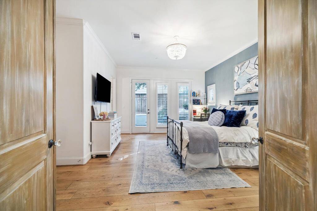 The first floor secondary bedroom features custom painted double entry doors and access to the rear patio.