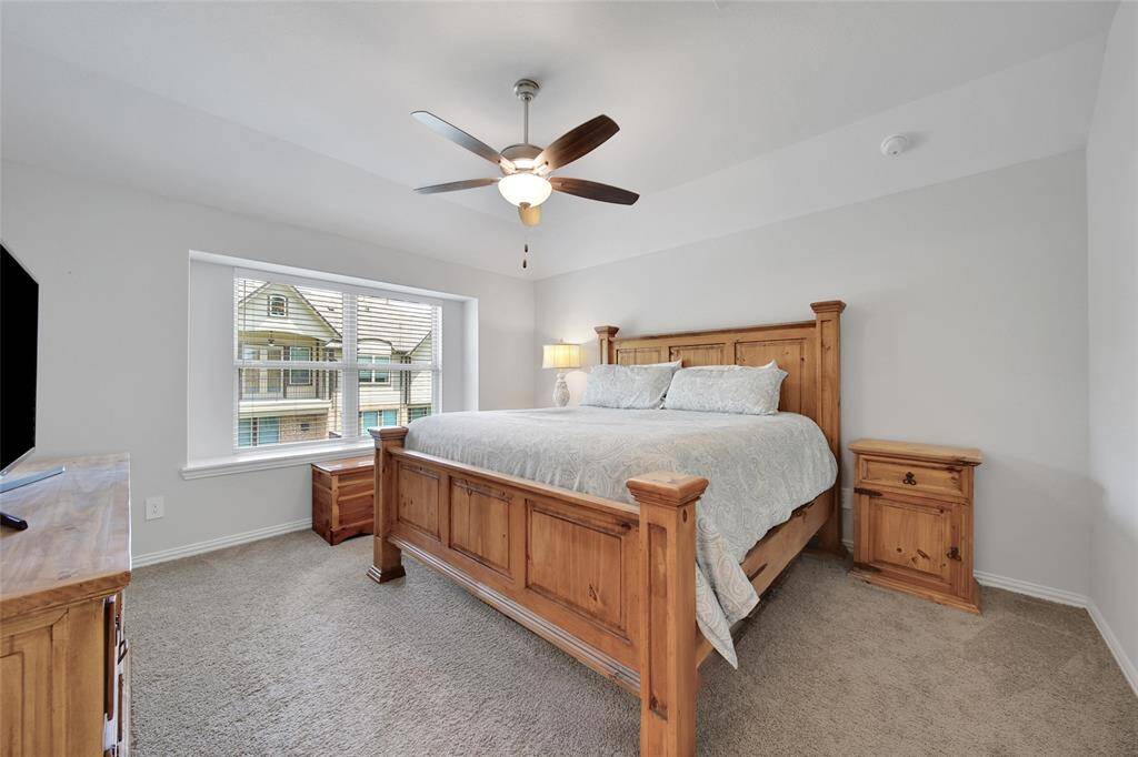 Primary with window ledge, ceiling fan and plush carpet add to this cozy room.